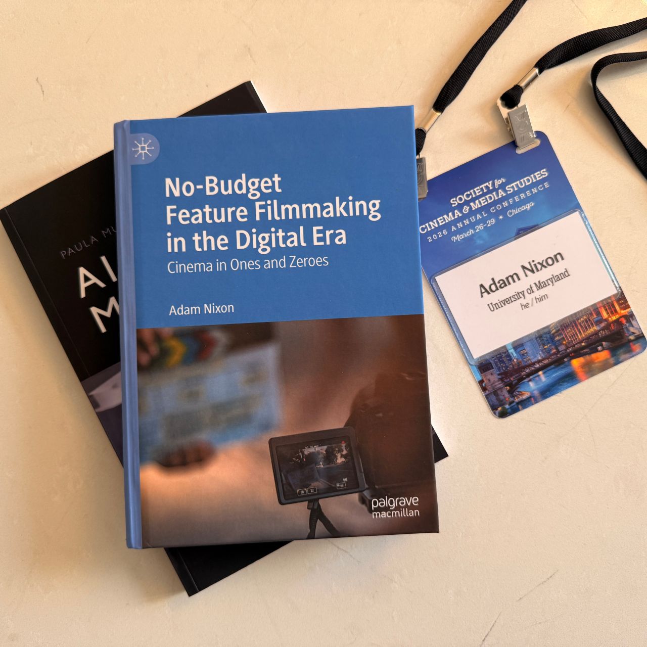 Adam Nixon's Book "No Budget Feature Filmmaking" on a white table with a lanyard 