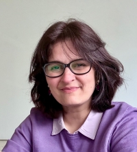 Headshot of Lamia Zia. She is wearing a purple top and glasses.