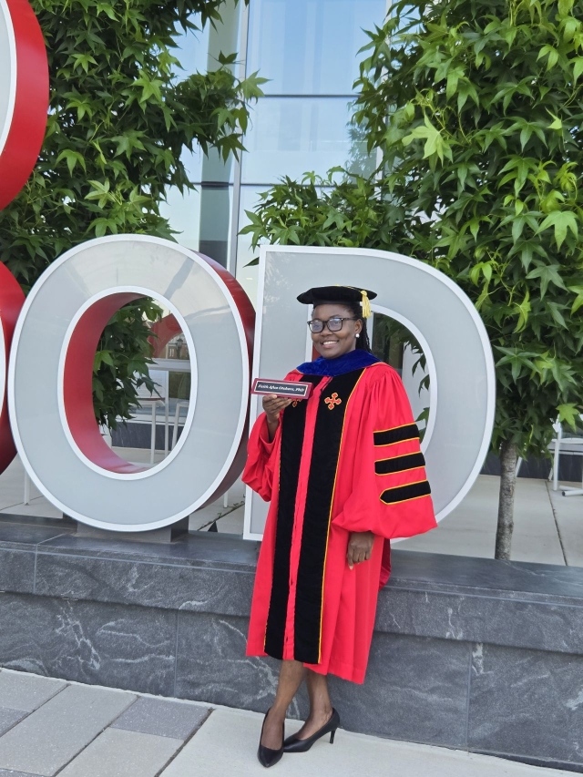Dr. Faith Otchere posed in PhD regalia. 