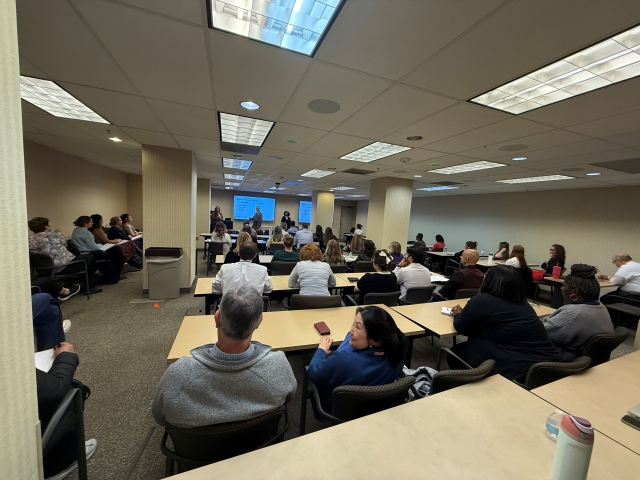 UMD OCC Members Present to Large Crowd at UMMC; Very large room full of desks and chairs, large audience tuning in 